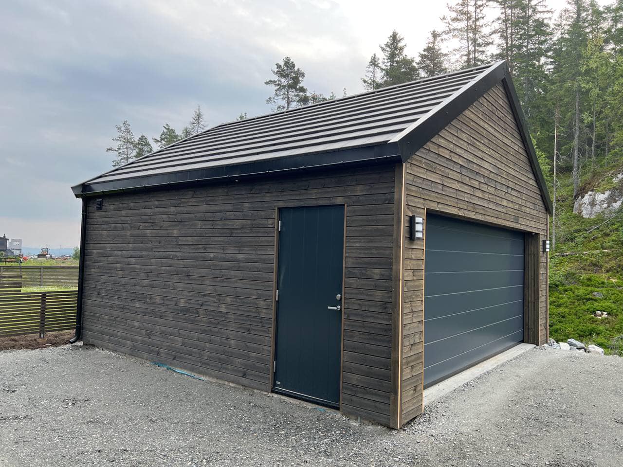 Frittstående dobbelgarasje i mørkbeiset trekledning bygget av tømrer på Nesodden