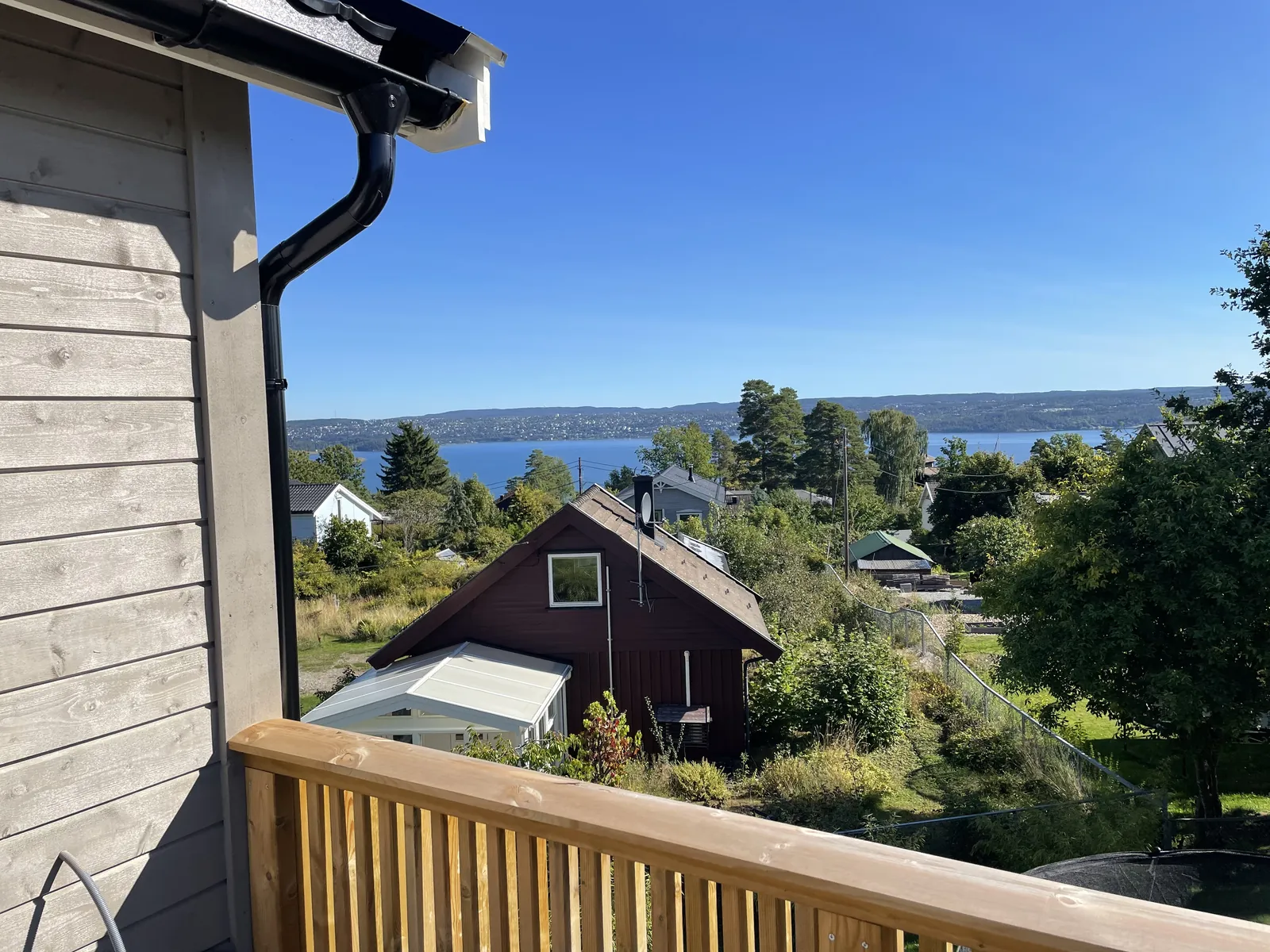 Terrasse i tre med nytt rekkverk og utsikt over Oslofjorden, bygget av tømrer på Nesodden